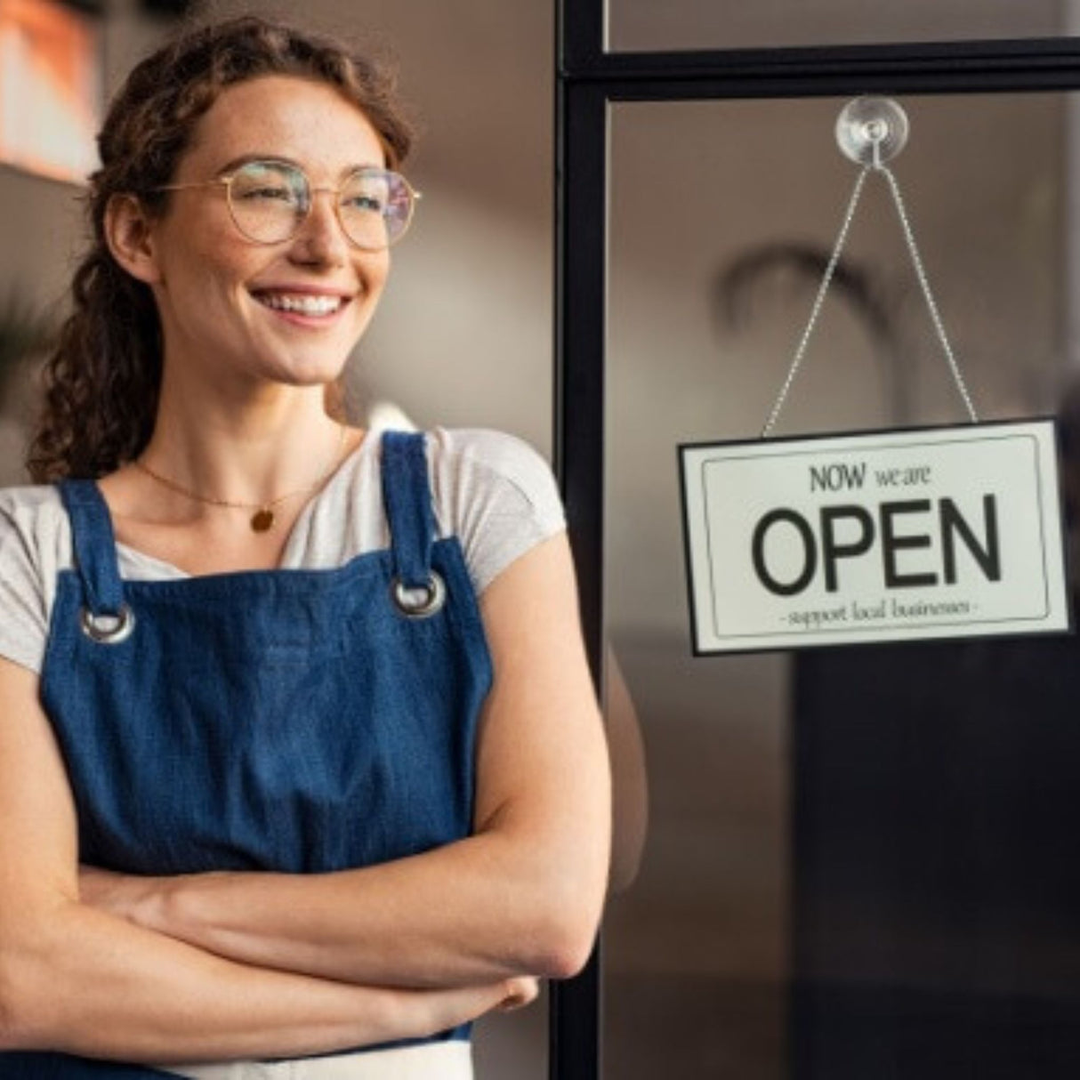 Young female worker in front of open sign