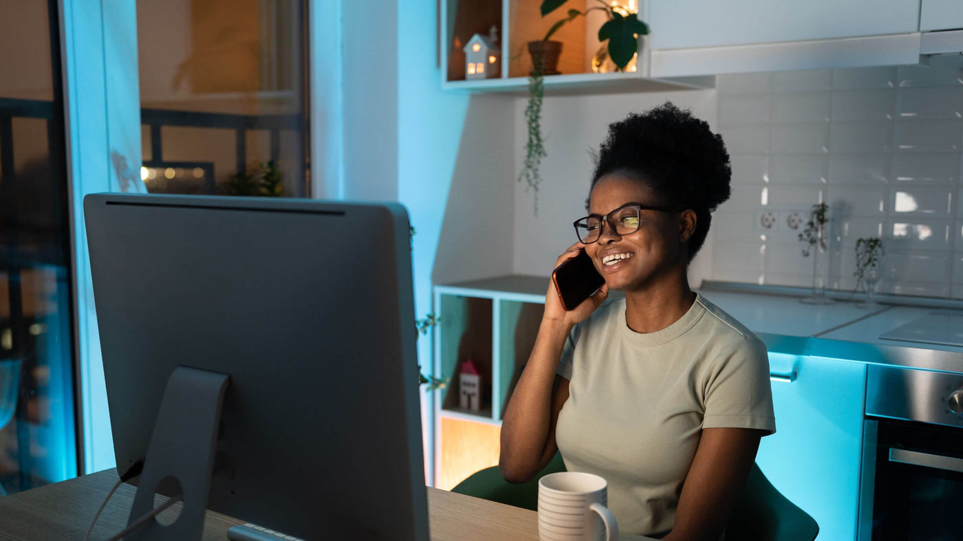 HR manager woman talking on phone with a computer and coffee mug.