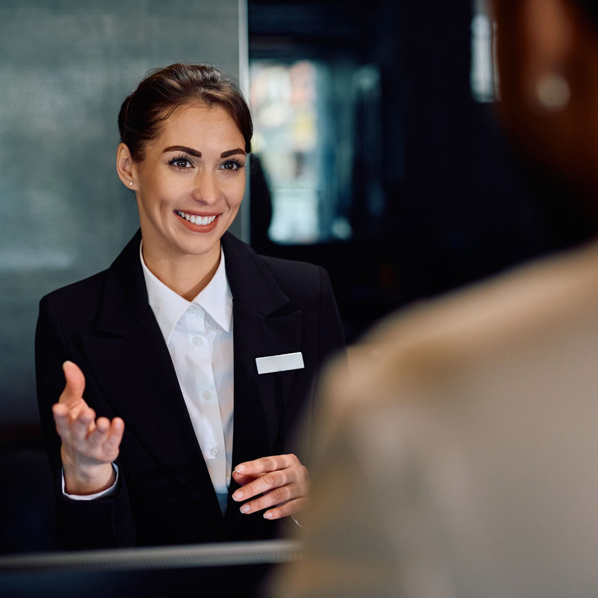 Happy female receptionist serving a guest