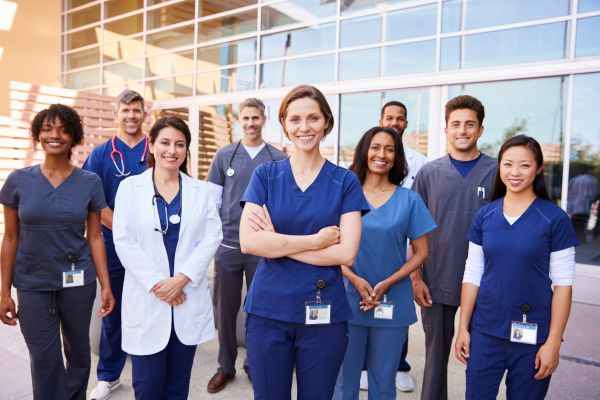 Group of healthcare professionals standing together in front of a building