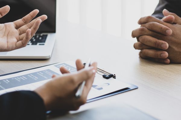 Employer and candidate hands on table with paperwork