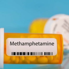 Prescription bottle labeled 'Methamphetamine' with pills 
